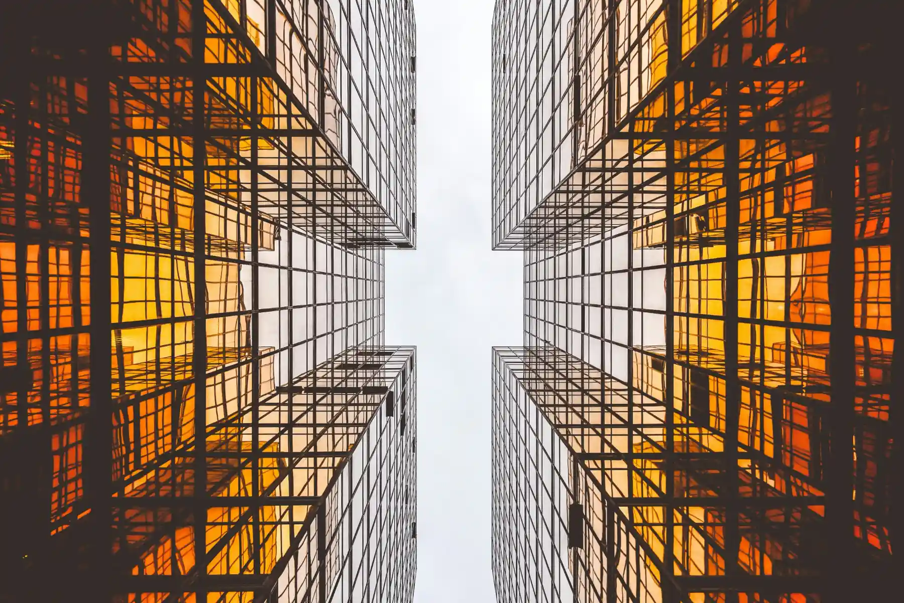 Modern architectural glass facade with upward perspective representing clarity, structure and precision in finance.